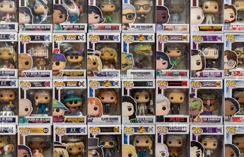 Collection of Funko Pop vinyl figures displayed in protective boxes arranged in rows on shelves