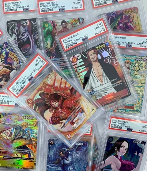 Graded One Piece trading cards with red certification labels, showing various character artwork and holographic finishes